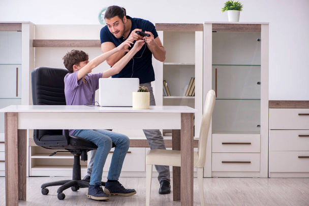 Young father and schoolboy playing computer games at home - Photo, Image