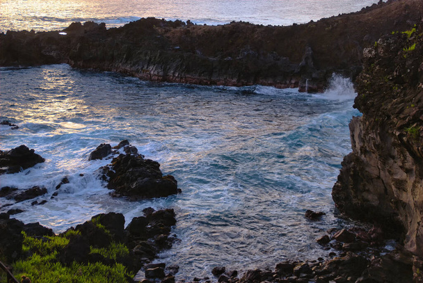 Закат в Ана-Тангата, вид на устье естественной морской пещеры рядом с Матавери с древними наскальными рисунками крапивы, остров Пасхи (Рапа-Нуи), Чили - Фото, изображение