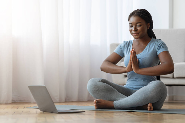 Yoga em casa. Calma senhora negra meditando na frente do laptop - Foto, Imagem