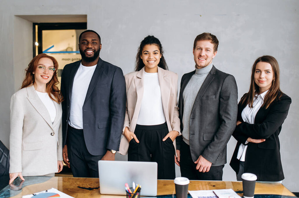 Portrait de l'équipe d'affaires multiraciale réussie debout dans le bureau moderne. Groupe de gens d'affaires travaillent ensemble, souriant. Des hommes et des femmes confiants regardent la caméra, le concept de travail d'équipe - Photo, image