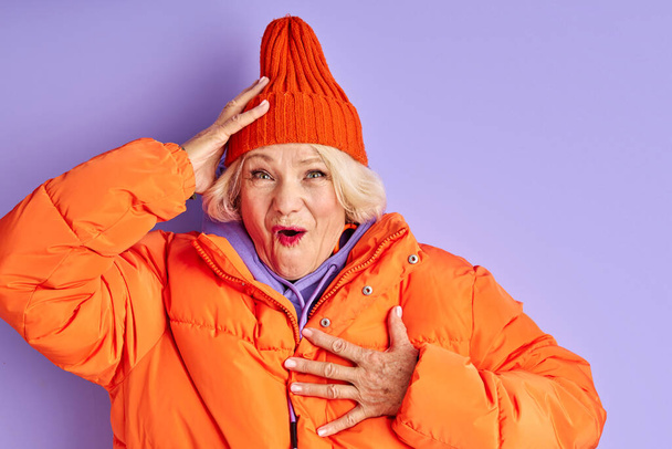 surprised emotional senior lady in orange clothes - Zdjęcie, obraz