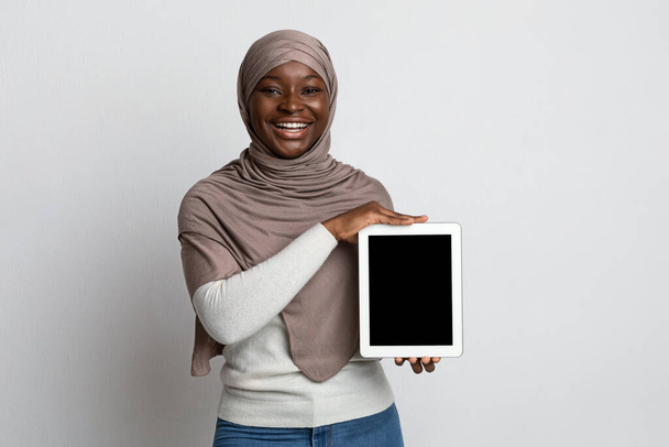 Tableta digital con pantalla negra en manos de mujer musulmana africana - Foto, imagen