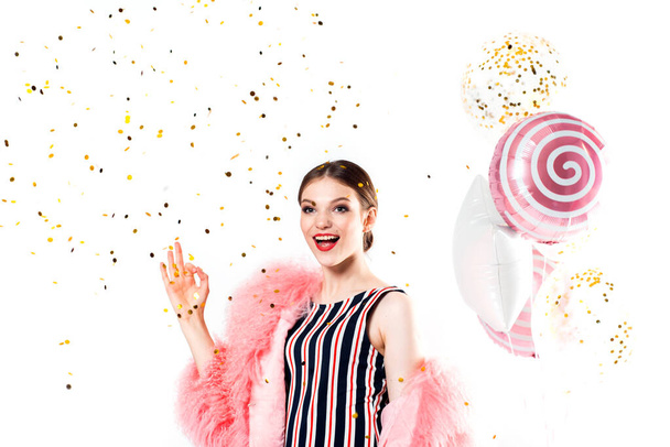 Funny woman celebrating with air balloons isolated white. Shows hand okay. in a pink fur coat, golden tinsel.Vivid emotions, surprise and joy, laughter and scream.Birthday holiday party - Φωτογραφία, εικόνα