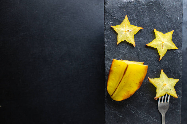 fresh carambola star fruit cut into slices ready to cook and eat on the table for healthy meal snack outdoor top view copy space for text food background rustic image keto or paleo diet - Fotoğraf, Görsel