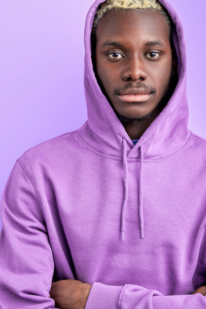 calm serious black male in casual purple pullover looks at camera - Foto, Imagem