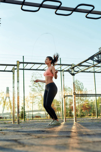 Young mixed race sportive girl skipping with jumping rope - Valokuva, kuva