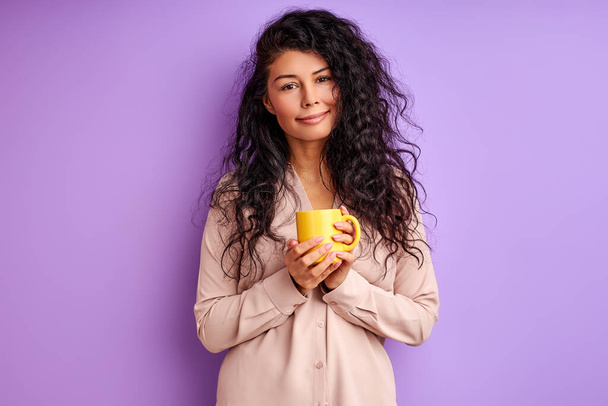 pretty smiling female holding yellow mug in hands - Foto, Bild