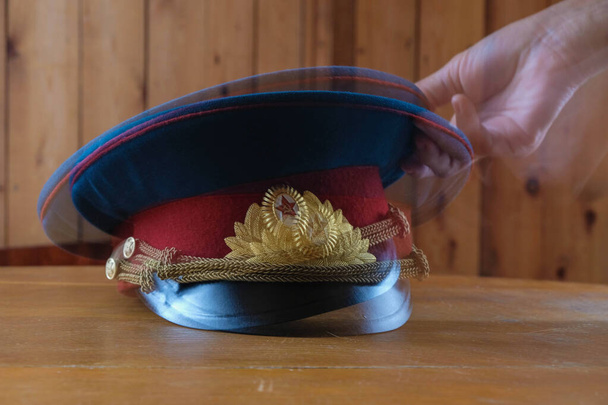 Μεγάλη έκθεση. Θολή εικόνες. Αρχηγός Σοβιετικού αστυνομικού. Το χέρι του ανθρώπου παίρνει ένα καπέλο. - Φωτογραφία, εικόνα