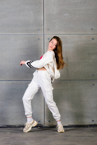 Χαριτωμένο έφηβος χορός hip hop σε ανακλαστικό παντελόνι, σε ένα στούντιο με νέον φωτισμό. Αφίσα χρωμάτων χορού. - Φωτογραφία, εικόνα