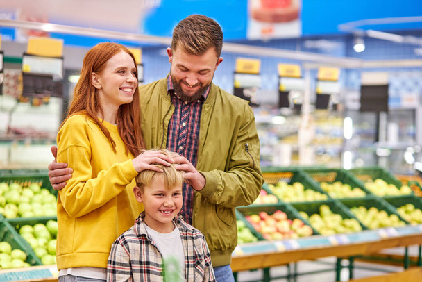 cheerful caucasian family have fun with son in grocery store - Foto, imagen