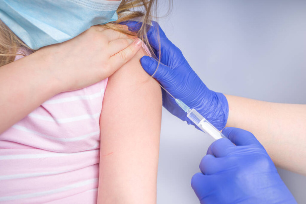 Uzyskać koncepcję szczepionki koronawirusowej, otrzymanie szczepionki przeciw zakaźnemu wirusowi HIV-19, Lekarz wstrzykujący szczepionkę w ramię małej dziewczynki rasy kaukaskiej, zdrowa i medyczna koncepcja - Zdjęcie, obraz