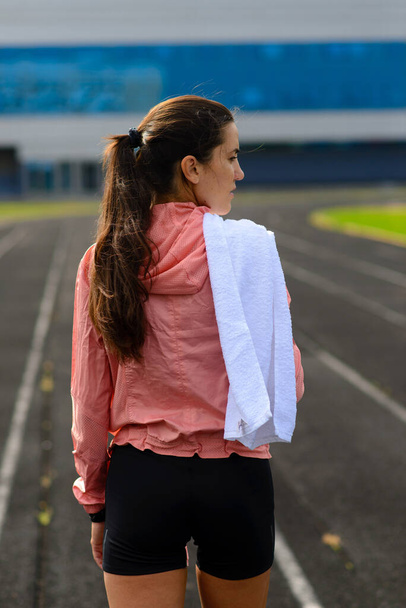 Foto al aire libre de la joven atleta corriendo en el hipódromo. Deportista profesional durante la sesión de entrenamiento. - Foto, imagen