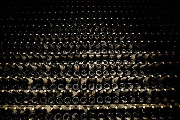 Stojak na piwnice z mnóstwem zakurzonych butelek wina. Technologia produkcji wina musującego. Argentyna - Zdjęcie, obraz