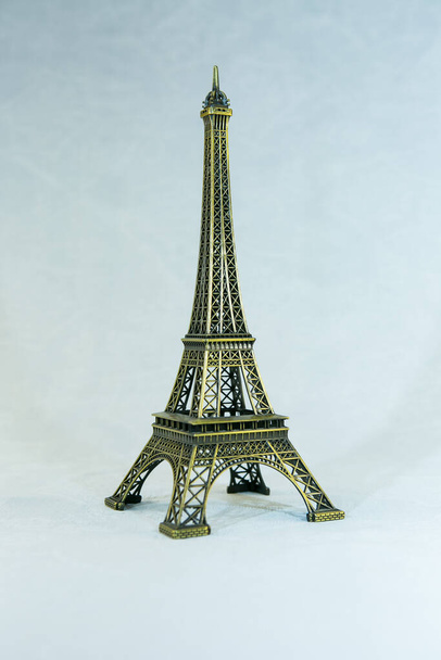 白い背景に隔離されたエッフェル塔のフィギュアの小さなブロンズコピー。パリの主な魅力. - 写真・画像