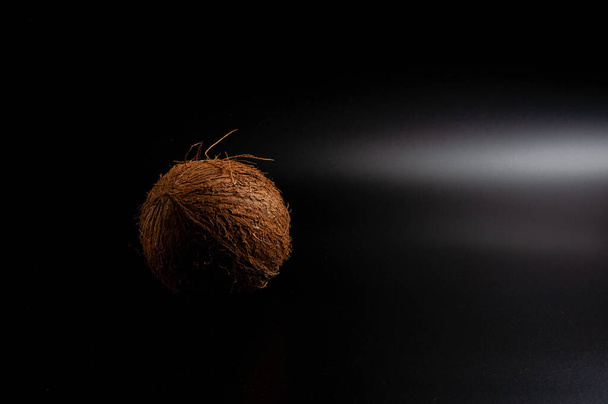 whole coconut on black background - Fotoğraf, Görsel
