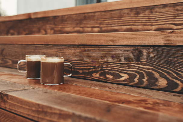 Deux tasses de café dans le fond de terrasse brun en bois - Photo, image