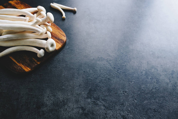 Cooking white mushrooms on the dark gray background - 写真・画像