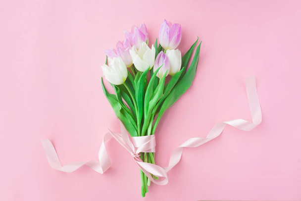 Bouquet of tulips on a pink pastel background. Wonderful spring breakfast on Mother's Day or Women. Flat lay. View top. Selective focus - Φωτογραφία, εικόνα