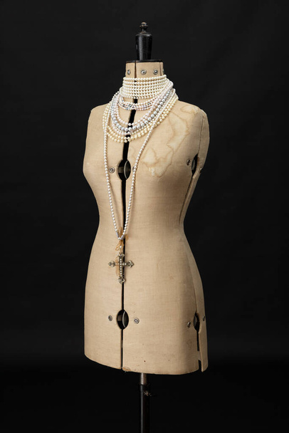 A vintage dressmakers dummy with pear necklaces draped around its neck - Photo, Image