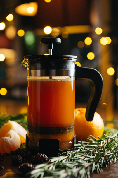 Tangerine tea in French press on the table in restaurant. Winter and autumn hot drink. - Foto, Imagem