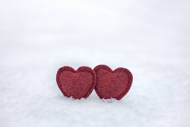 δύο απαλές κόκκινες καρδιές σε λευκό χνουδωτό χιόνι του χειμώνα, σύμβολο αγάπης και ευτυχίας - Φωτογραφία, εικόνα