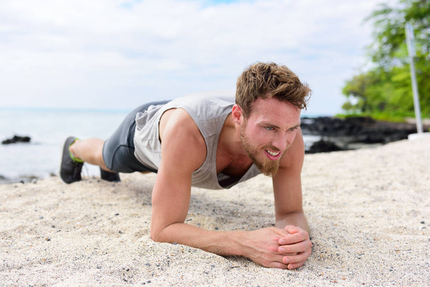 Man training core fitness doing plank on beach - Valokuva, kuva