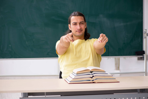 Joven estudiante masculino preparándose para los exámenes en el aula - Foto, Imagen