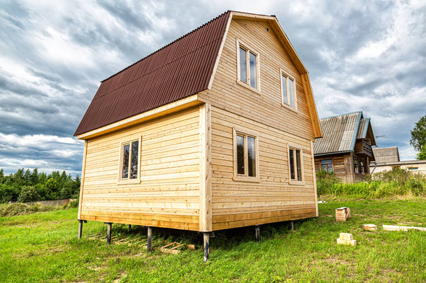 Nowy mały drewniany dom w budowie na wsi w letni słoneczny dzień - Zdjęcie, obraz