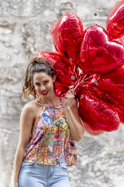 Sevgililer Günü için bir düzine balonu olan güzel bir esmer manken. - Fotoğraf, Görsel