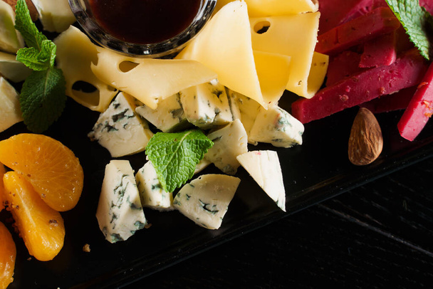 Assiette au fromage en gros plan. Planche à manger avec parmesan savoureux, dorblu, fromage à pâte molle, camembert. Livraison de nourriture - Photo, image