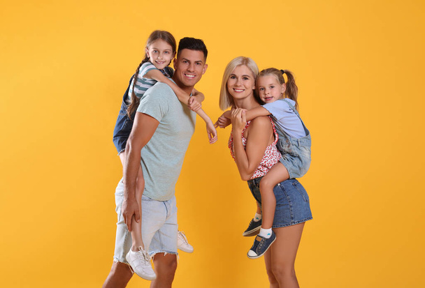 Portrait of happy family on yellow background - Foto, afbeelding