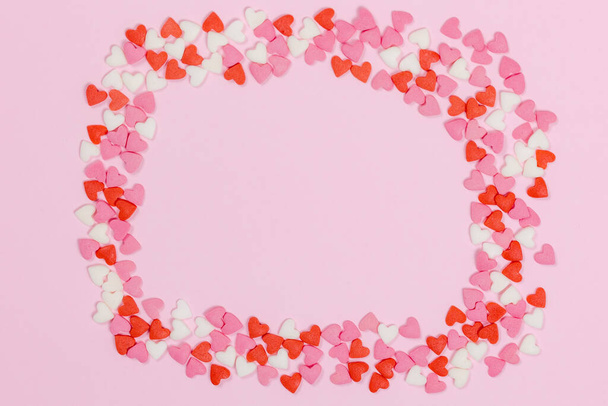 Heart shaped candies scattered on pink background love wedding concept. Valentines day pattern background. Flat lay top view. Copy space - Photo, Image
