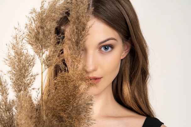  girl studio fashion portrait on the background of dry reed cane - Photo, Image