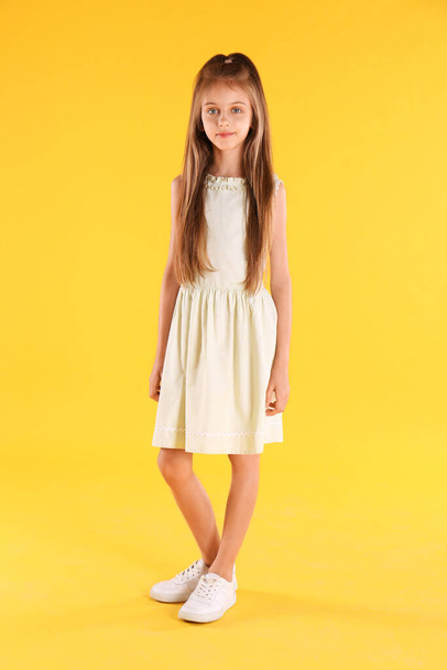 Full length portrait of cute little girl on yellow background - Foto, Imagem