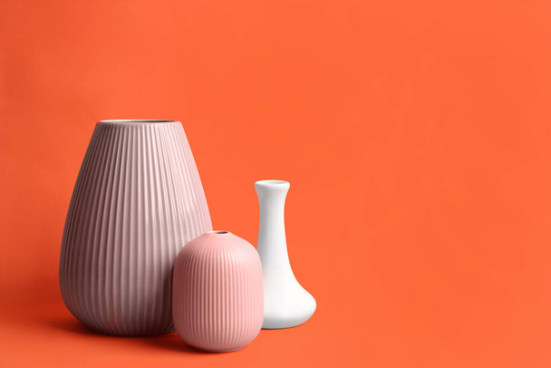 Stylish empty ceramic vases on orange background, space for text - Photo, image