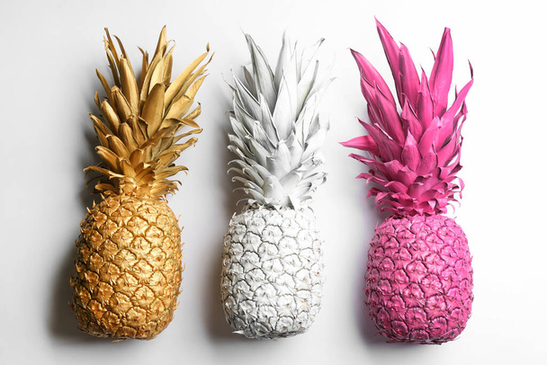 Painted pineapples on white background, top view. Creative concept - Φωτογραφία, εικόνα