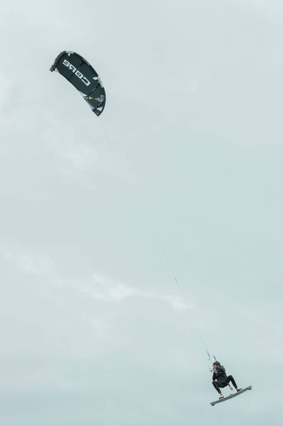 кайтсерфер летает по небу Северного моря в Германии - Фото, изображение