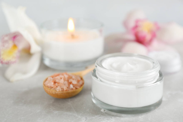 Beautiful spa composition with cream and sea salt on marble table, closeup - Zdjęcie, obraz