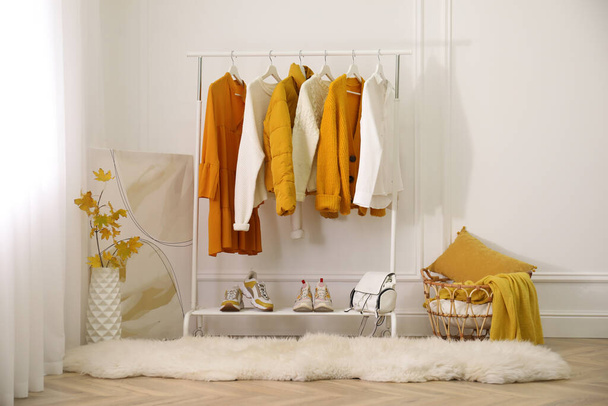 Rack with stylish warm clothes, shoes and accessories in modern dressing room - Фото, зображення