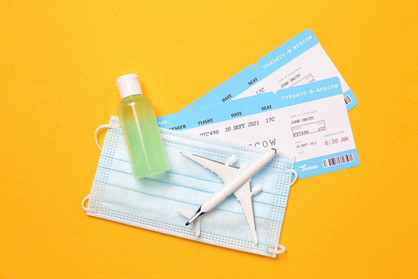 Flat lay composition with tickets and protective mask on yellow background. Travel during quarantine - Photo, image