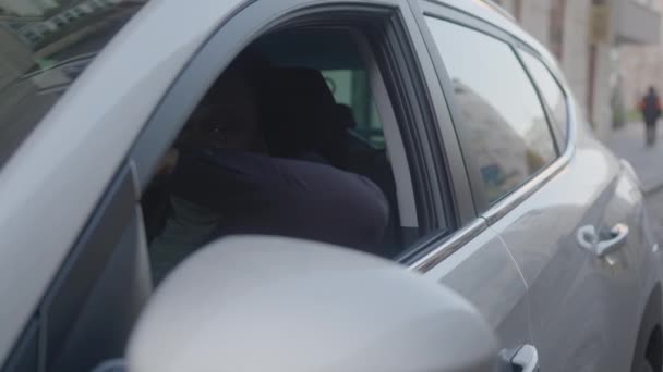 Emocionado negro afro-americano sentado no banco dos motoristas em seu carro novo e mostrando o polegar para cima - Filmagem, Vídeo