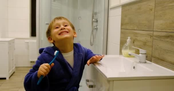 Pieni blondi poika poika harjaa hampaita - Materiaali, video