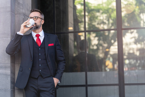 Mann im Business-Anzug mit einer Tasse Kaffee. Business-Lebensstil in der Kaffeezeit am Morgen daylight.man Gefühl frisch und glücklich mit Zuversicht auf Erfolg. - Foto, Bild