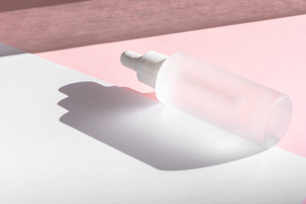 Λάδι ορού με κολλαγόνο και πεπτίδιο σε λευκό διάφανο μπουκάλι με σταγονόμετρο σε ροζ φόντο με σκιές. Περιποίηση της επιδερμίδας περιποίηση της επιδερμίδας ιατρική περιποίηση mockup συσκευασία καλλυντικό προϊόν - Φωτογραφία, εικόνα
