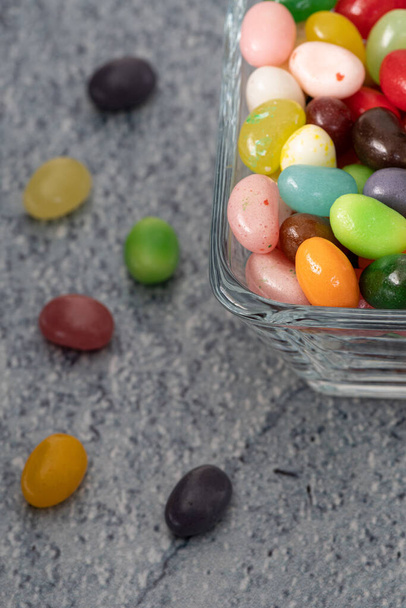 Jelly fazole na modrém pozadí, slavnostní a barevné složení s bonbóny, makro detail záběr top view - Fotografie, Obrázek