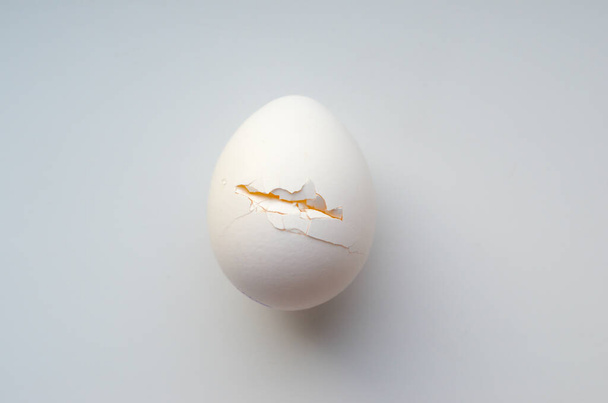 Cracked egg on a white background - Фото, изображение