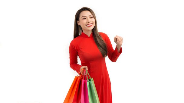 Young Asian woman with shopping bags for lunar New Year festival on white background  - Valokuva, kuva