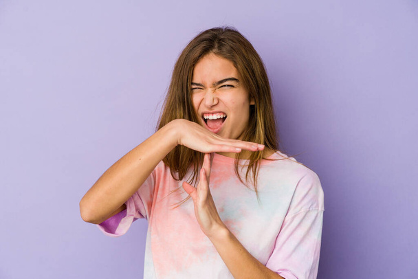 Young skinny caucasian girl teenager on purple background showing a timeout gesture. - Photo, Image