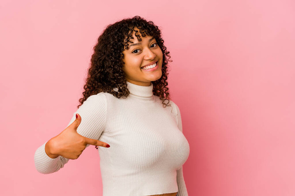 Молода афроамериканка афро-жінка ізольована людина, вказуючи вручну на простір копіювання сорочки, горда і впевнена
 - Фото, зображення