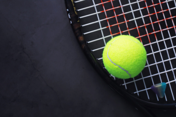 Спорт и здоровый образ жизни. Теннис. Желтый мяч для тенниса и ракетка на столе. Спортивный фон с теннисной концепцией. - Фото, изображение